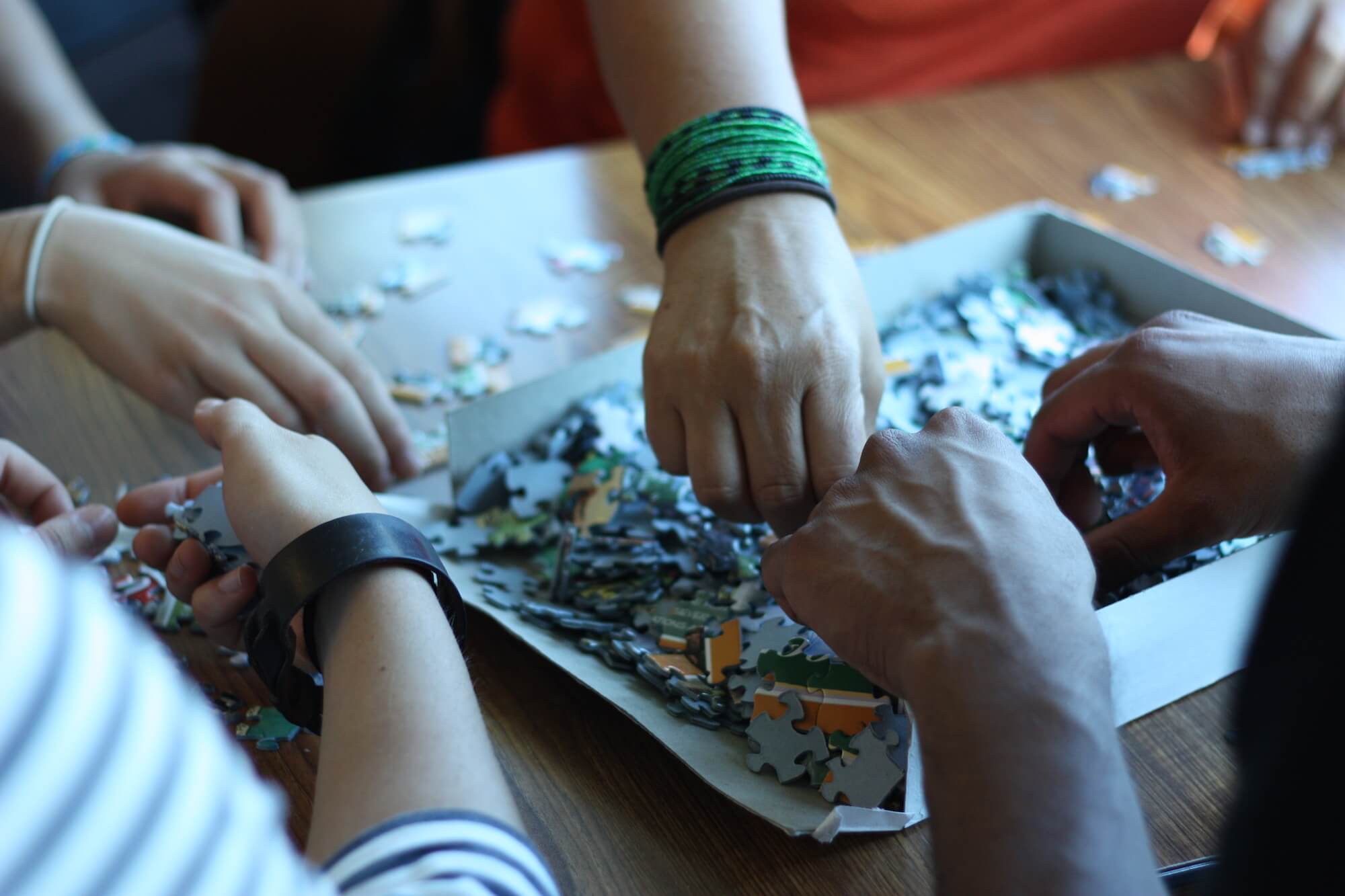 Hands building puzzle together