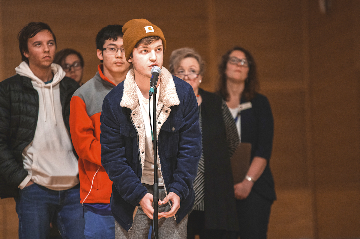 photo of student posing a question, short line behind him