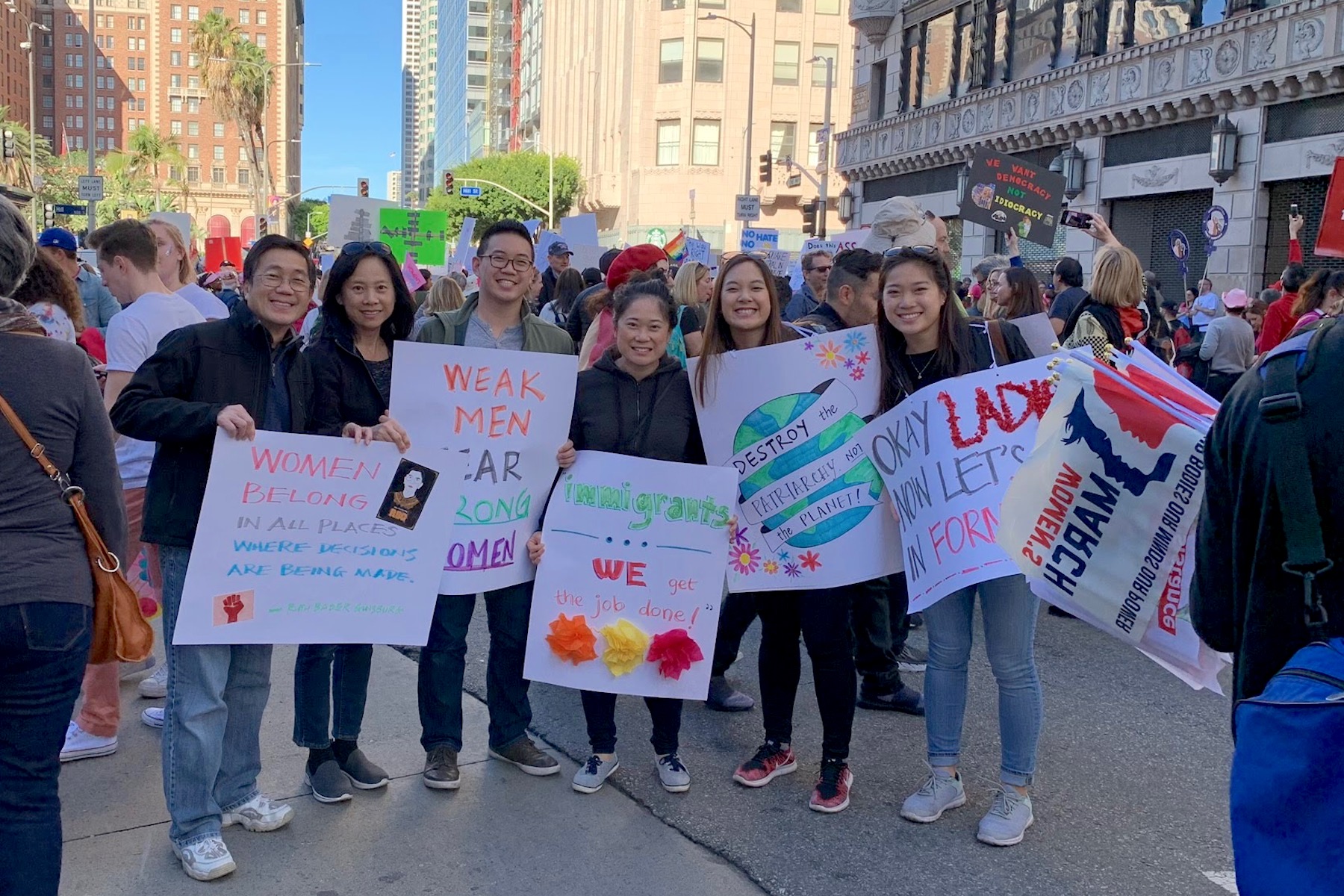 May and Sam Lim at LA Women's March, holding signs of support with their parents and sister.